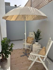 une terrasse avec une chaise et un parasol dans l'établissement Norhan's Studio, à Riyad