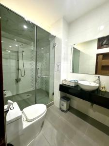a bathroom with a shower and a toilet and a sink at Tinahouse in Danang