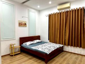 a bedroom with a bed and a curtain at Tinahouse in Danang