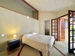 a bedroom with a bed and a tv in it at Manaca House_ refúgio charmoso_Centro c/ 2 quartos in Ubatuba