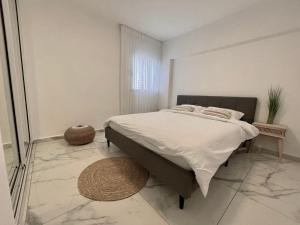 a bedroom with a large bed in a white room at 4 חדרים מרווחת 138 מ"ר חניה חינם קרוב לים in Eilat