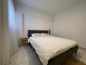 a bedroom with a large bed with white sheets at 4 חדרים מרווחת 138 מ"ר חניה חינם קרוב לים in Eilat