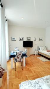 a living room with a table and a couch at Lavender - City Room with free parking in Pula