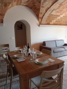 a dining room table with chairs and a couch at Country House L'Oliveto in Marta