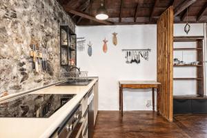 una cucina con parete in pietra e lavandino di Casa Tea, un lugar con encanto a Tazacorte