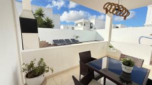 een balkon met een tafel en stoelen op een dak bij Casa Lomas in Playa Blanca