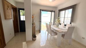 een witte eetkamer met een witte tafel en stoelen bij Casa Lomas in Playa Blanca