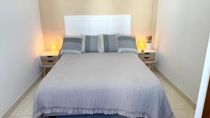 een slaapkamer met een groot bed met twee nachtkastjes bij Casa Lomas in Playa Blanca +18 foto's