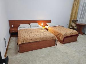 a bedroom with two beds and a table with a lamp at Rest Hostel Airport Modlin in Nowy Dwór Mazowiecki