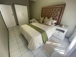 ein Schlafzimmer mit einem großen Bett und einer grünen Decke in der Unterkunft AfricaLove on Tiger Suite in Pretoria