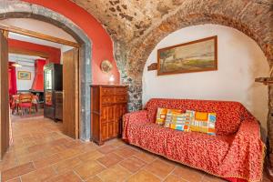 a bedroom with a red bed in a stone room at Etnalandhauser in Piedimonte Etneo +79 photos