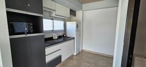 a kitchen with black and white cabinets and a window at Charlie Suites en el casco histórico de Salta in Salta