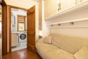 a living room with a couch and a washing machine at Gina House in Stintino