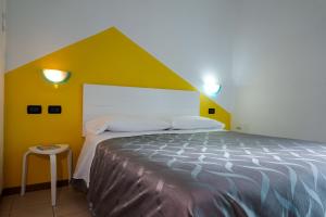 a bedroom with a large bed with a yellow wall at Residence Villa Azzurra in Rimini +88 photos