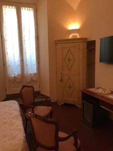 a hotel room with a bed and a desk and a television at Casalbergo in Siena