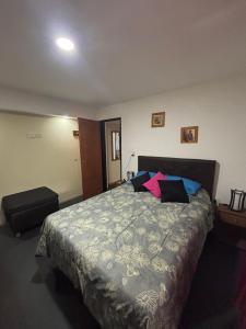 Un dormitorio con una cama grande con almohadas. en Hospedaje en Merlo, en Merlo