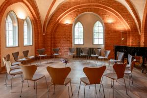 una grande stanza con sedie e un pianoforte a coda di Klosterhotel Lehnin a Lehnin