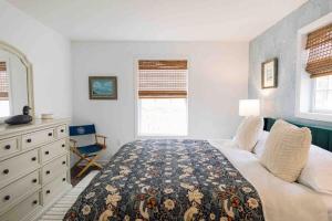 a bedroom with a bed and a dresser and a window at Sea Fog Cottage in Camden