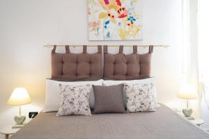 a bed with a brown headboard and pillows at Villa Camilla by SALENTO OASIS in Porto Cesareo