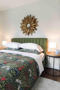 una camera da letto con un letto e uno specchio sul muro di Sea Fog Cottage a Camden