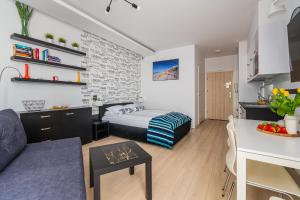 una camera da letto con un letto e un soggiorno di APARTAMENTY MIERZEJA - MARINA, Kąty Rybackie, Klimatyzacja,100 m od Zalewu Wiślanego a Kąty Rybackie