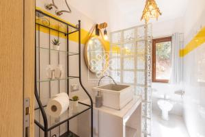 a bathroom with a sink and a toilet and a mirror at Wendy House in Stintino