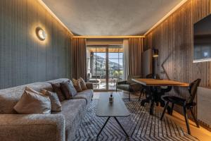a living room with a couch and a table at Quellenhof Luxury Resort Passeier in San Martino