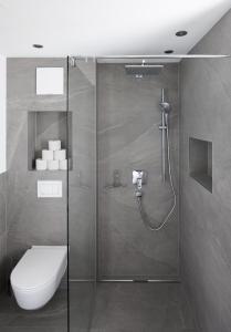 a bathroom with a shower with a toilet and a sink at Ferienwohnung Simlhof in Inzing