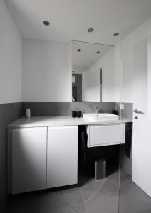 a white bathroom with a sink and a mirror at Ferienwohnung Simlhof in Inzing
