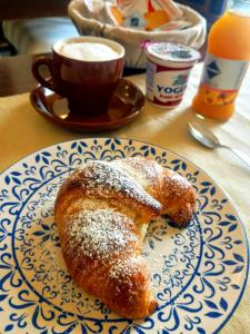 a plate with a pastry on a table with a cup of coffee at B&B Dei Bottai in Gallipoli