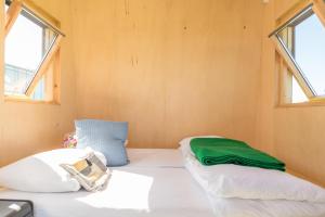 two beds in a small room with two windows at Hihahut De Zonnepost in Oud-Ade