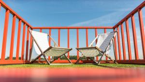 two chairs sitting on a balcony at Hihahut De Zonnepost in Oud-Ade
