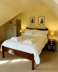 ein Schlafzimmer mit einem großen Bett mit weißen Laken und Kissen in der Unterkunft Glen Dessary Estate - Fully Catered Bespoke Highland Lodge in Spean Bridge