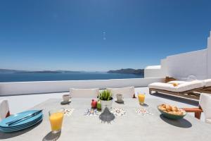 una mesa con comida y bebida en el balcón en Perfect Purity, en Oia