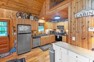 a kitchen with wooden cabinets and appliances in a cabin at Mountain Getaway with Hot Tub & Game Room cabin in Cleveland