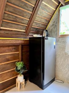 a kitchen with a refrigerator and a potted plant at Zerohouse in Ban Bang Bao