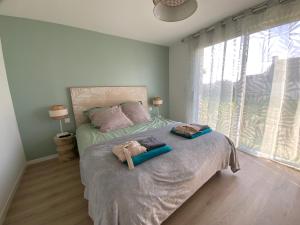 a bedroom with a bed with two towels on it at Maison vue mer prés avec SPA près des plages in Plouhinec
