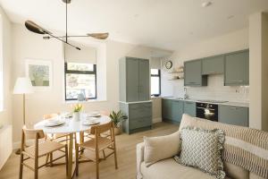 a kitchen and living room with a table and chairs at The Old Schoolhouse River View in Donegal