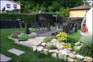 a garden with chairs and a stone walkway in a yard at Ad Maiora Luxury Glamping private Spa in Faedis