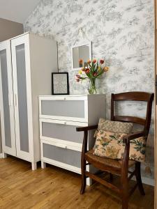 a dressing table with a chair and a vase of flowers at La Grange Charton Gite in Champagne-Mouton +25 photos