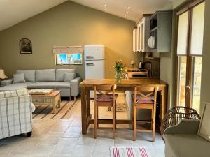 a kitchen and living room with a table and a couch at La Grange Charton Gite in Champagne-Mouton