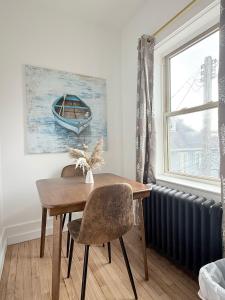 a dining room table with a bench and a window at Downtownrochesterretreatstylishstudiowithkitchen in Rochester