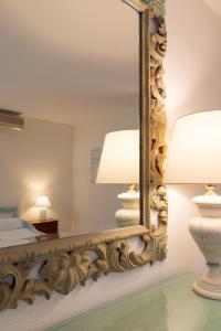 Un espejo en un dormitorio con dos lámparas. en Casa Acqua e Pietra by Wonderful Italy, en Casa Tamponi