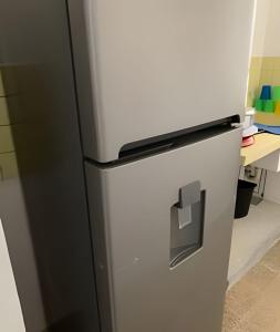 a refrigerator in a kitchen next to a desk at Cómodo departamento en el corazón de Cancún in Cancún