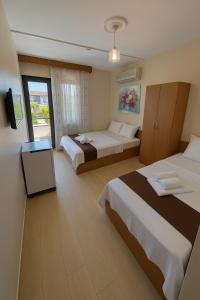 a hotel room with two beds and a television at Panorama Hotel Özdere in Ortaköy