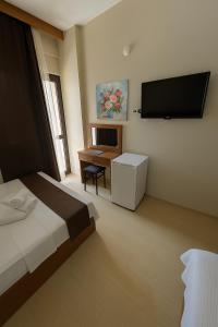a bedroom with a bed and a desk and a flat screen tv at Panorama Hotel Özdere in Ortaköy