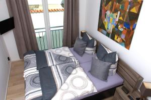 een slaapkamer met een bed met kussens en een schilderij bij Ferienwohnung Wilma in Ostseebad Sellin