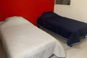 a bedroom with a bed and a red wall at Casa acogedora en Chetumal in Chetumal