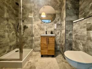 a bathroom with a sink and a toilet and a mirror at Apartament Bulwary 7 in Oświęcim +24 photos