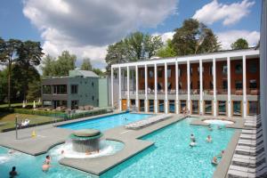 a pool in front of a building with people in it at Ferienwohnung Juliane in der Villa zum Kronprinzen direkt gegenüber der Saarow Therme in Bad Saarow